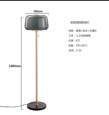 Modern nordic wood and glass floor lamp with dark gray double-layered glass shade on brass-finished metal base