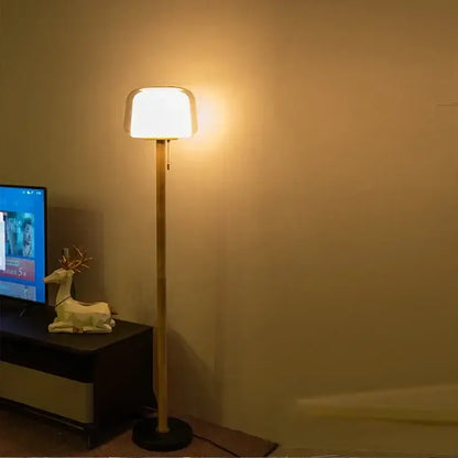 Modern nordic warm-toned floor lamp with sleek bamboo-style pole and soft rounded white shade for living room