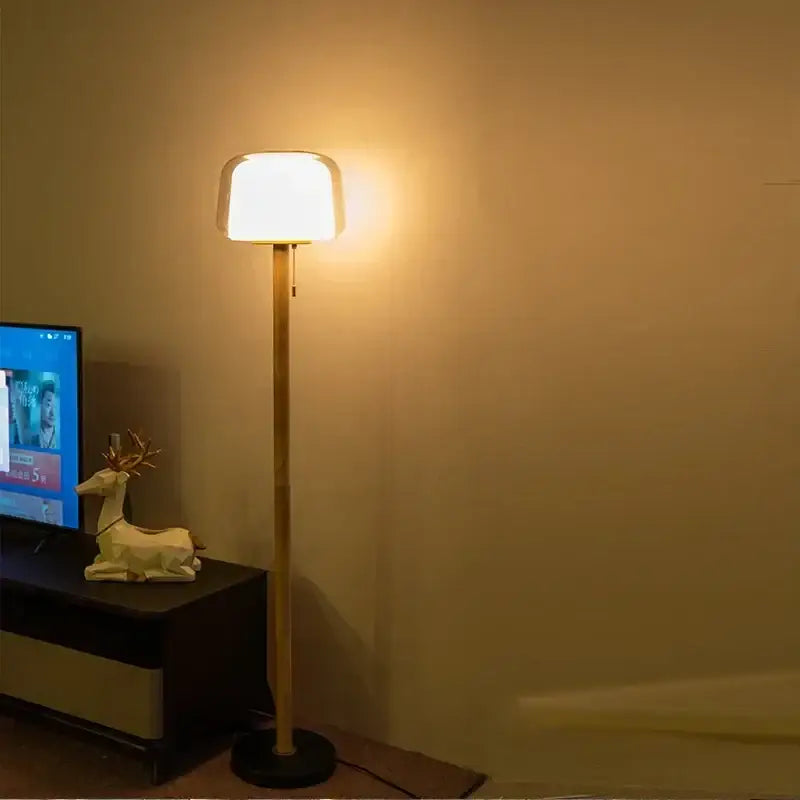 Modern nordic warm-toned floor lamp with sleek bamboo-style pole and soft rounded white shade for living room