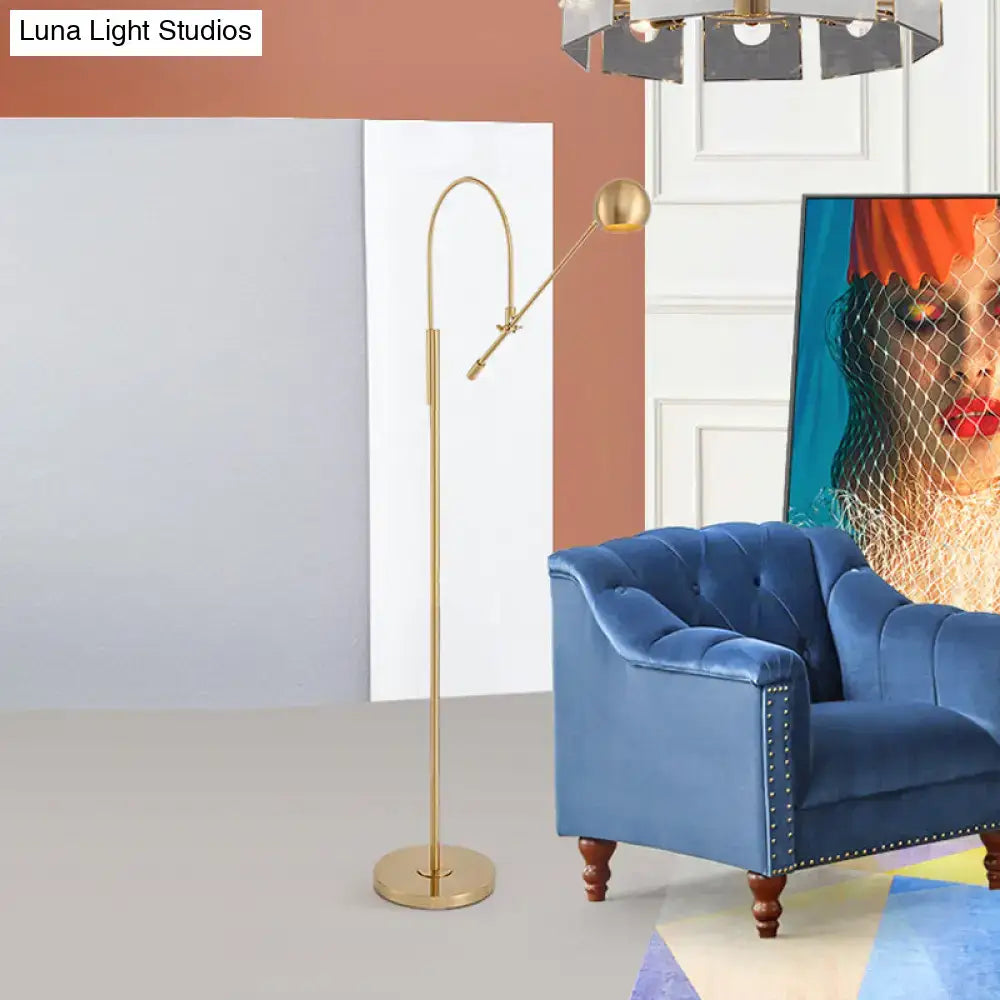 Gold-finished floor lamp with a slender, curved arm and adjustable head.