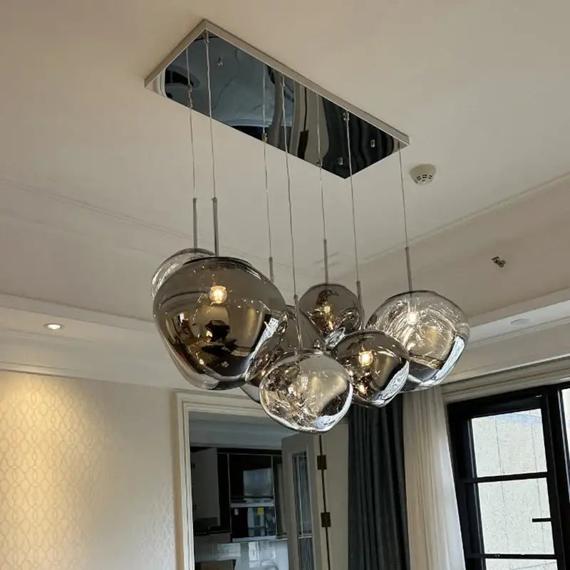 Modern organic form pendant light with chrome plated finish and spherical design on rectangular mirrored mount