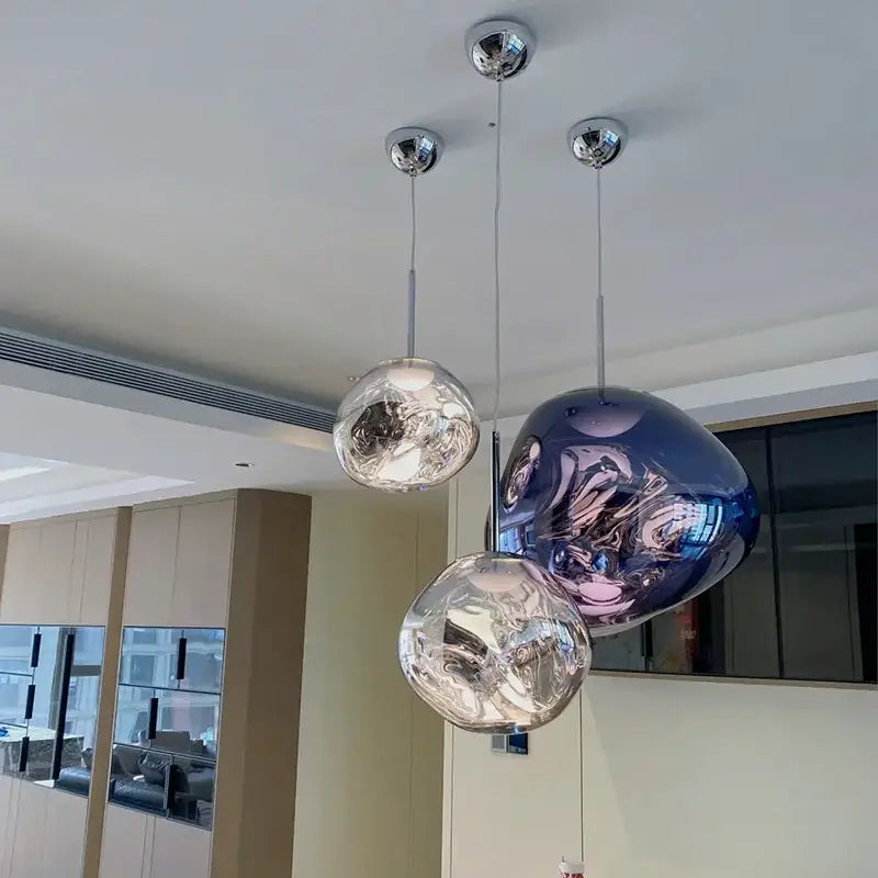 Three modern spherical pendant lights with organic form chrome plated finish for kitchen lighting