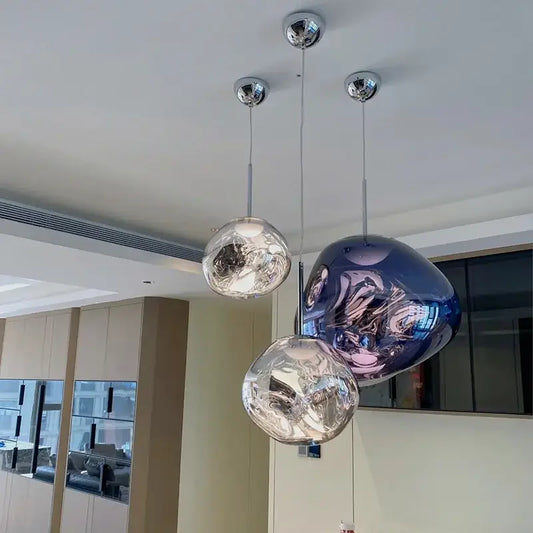 Three modern spherical pendant lights with organic form chrome plated finish for kitchen lighting
