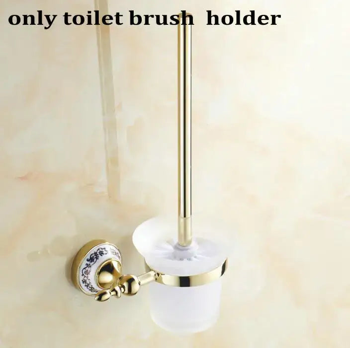 Modern ornate gold-toned toilet brush holder with white ceramic base and blue floral pattern in bath hardware set