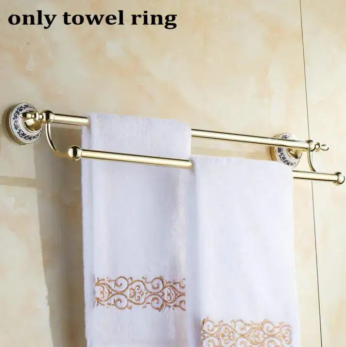 Modern ornate gold and white porcelain towel ring with double bars holds embroidered white towels in bath hardware set