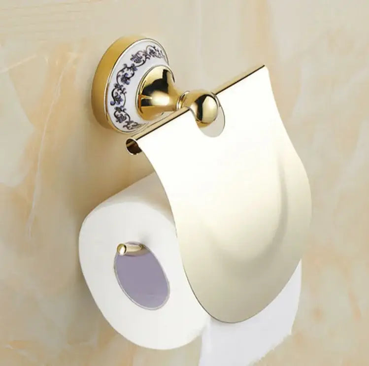 Modern ornate gold and white porcelain toilet paper holder with blue floral base, part of a bath hardware set