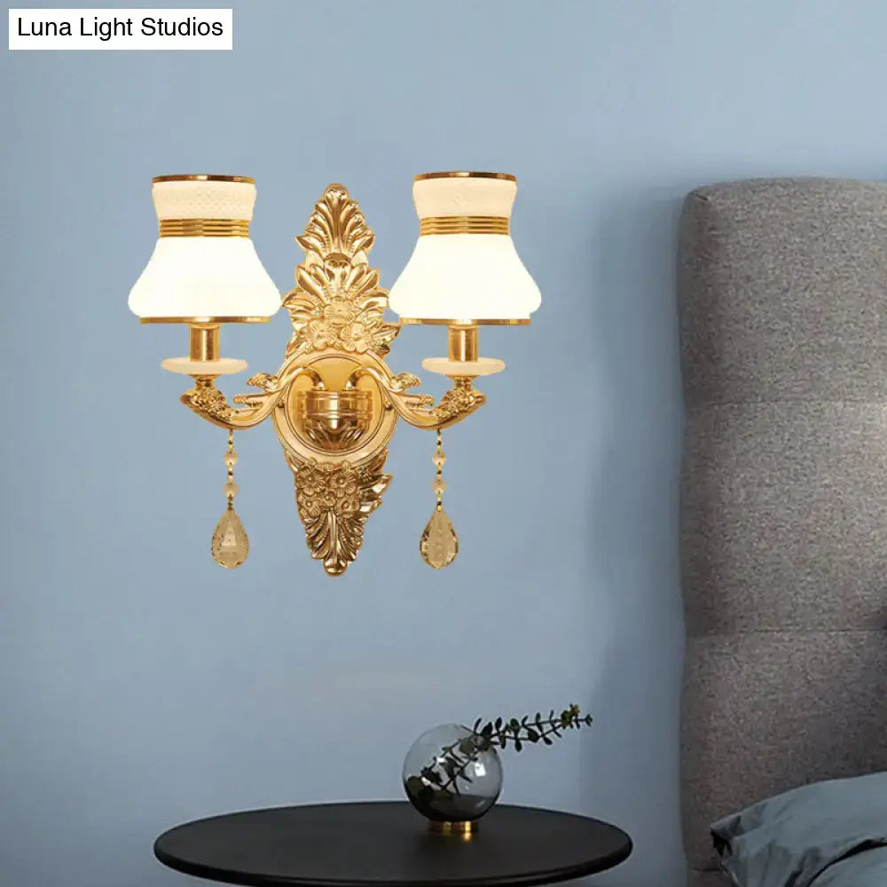 Modern ornate gold wall light with frosted glass shade features two white lampshades and crystal teardrop pendants