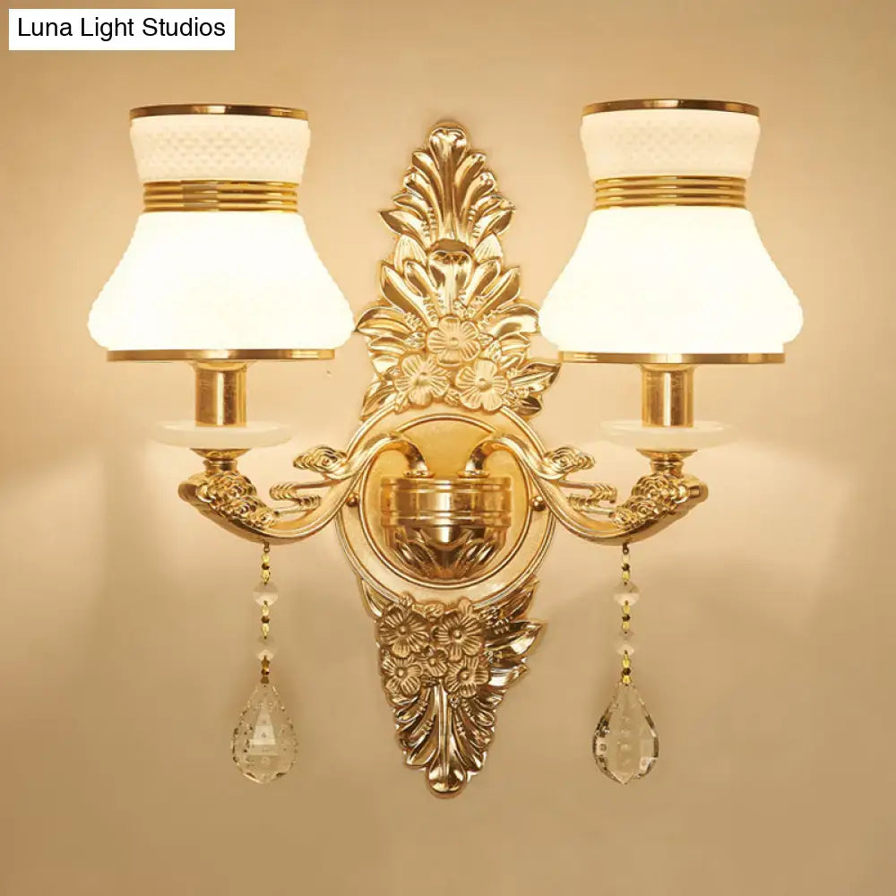 Modern ornate gold wall light with frosted glass shade featuring crystal teardrop pendants for bedroom sconce use