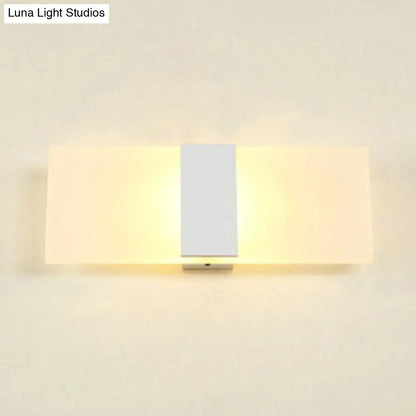 Modern oval rectangular convex led wall sconce with central silver metallic strip and frosted glass panels emitting warm light