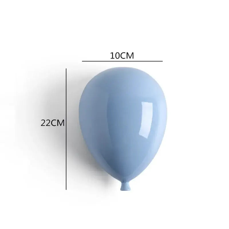 A sleek matte light blue ceramic balloon wall hanging decoration with a glossy sheen for children room