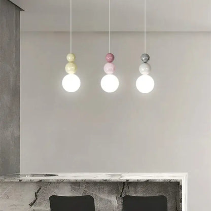 Three modern pendant lights with pastel yellow, soft pink, and matte gray glass globes for decorbites cream nordic decor