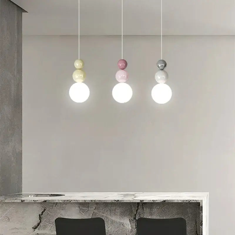 Three modern pendant lights with pastel yellow, soft pink, and matte gray glass globes for decorbites cream nordic decor