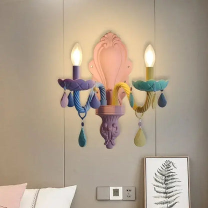 Pastel pink and purple ornate wall sconce with colorful braided cords and teardrop pendants in decorbites crystal chandelier for children room