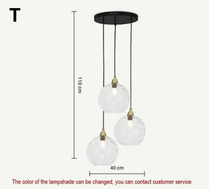 Modern three-light pendant light with clear faceted glass globes and brass fittings on black mount in polished chrome design
