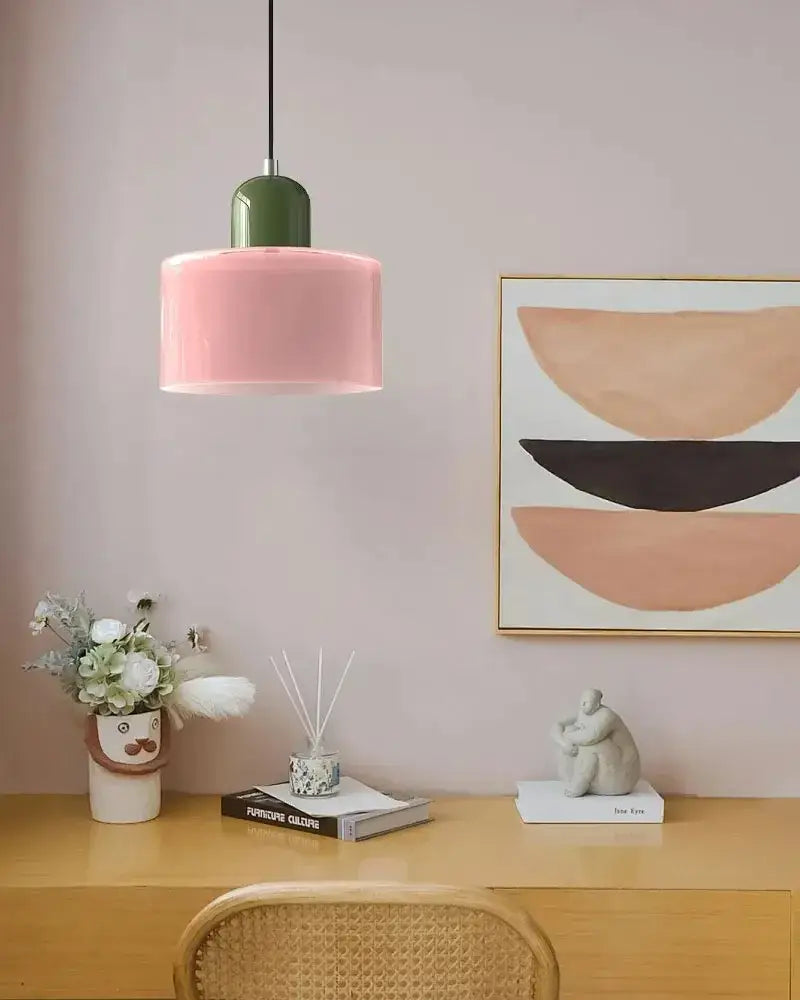 Modern pendant light with a matte pink glass shade and glossy green top for kitchen or dining room use