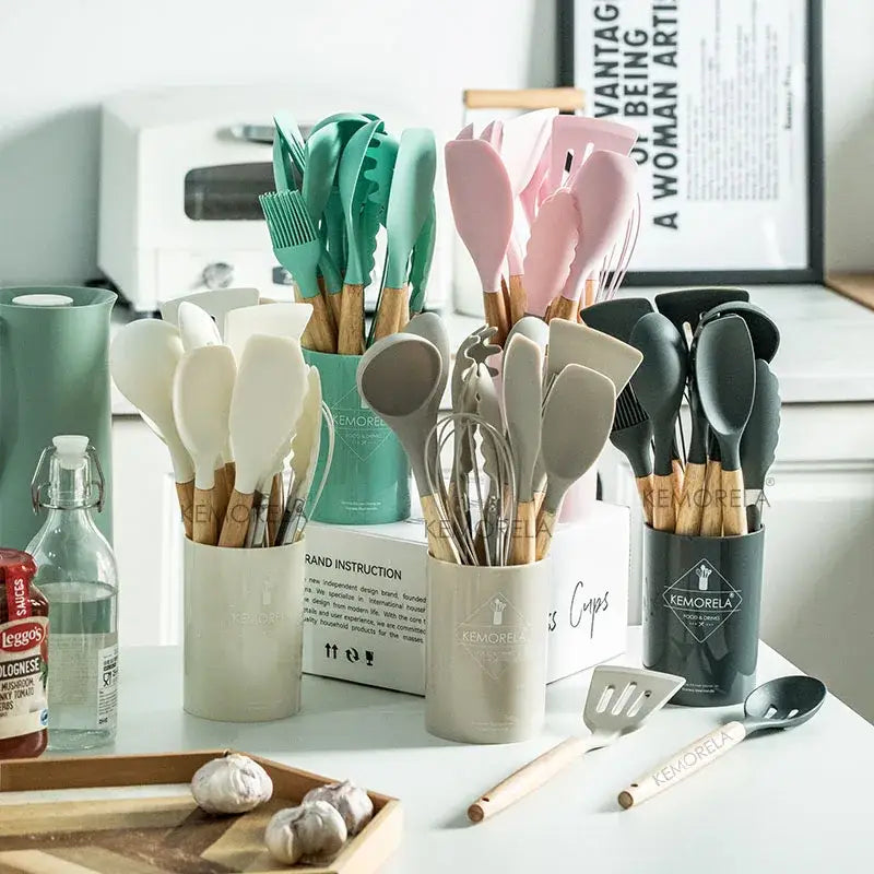 Set of pastel silicone kitchen utensil set with wooden handles in teal pink beige and black with storage box
