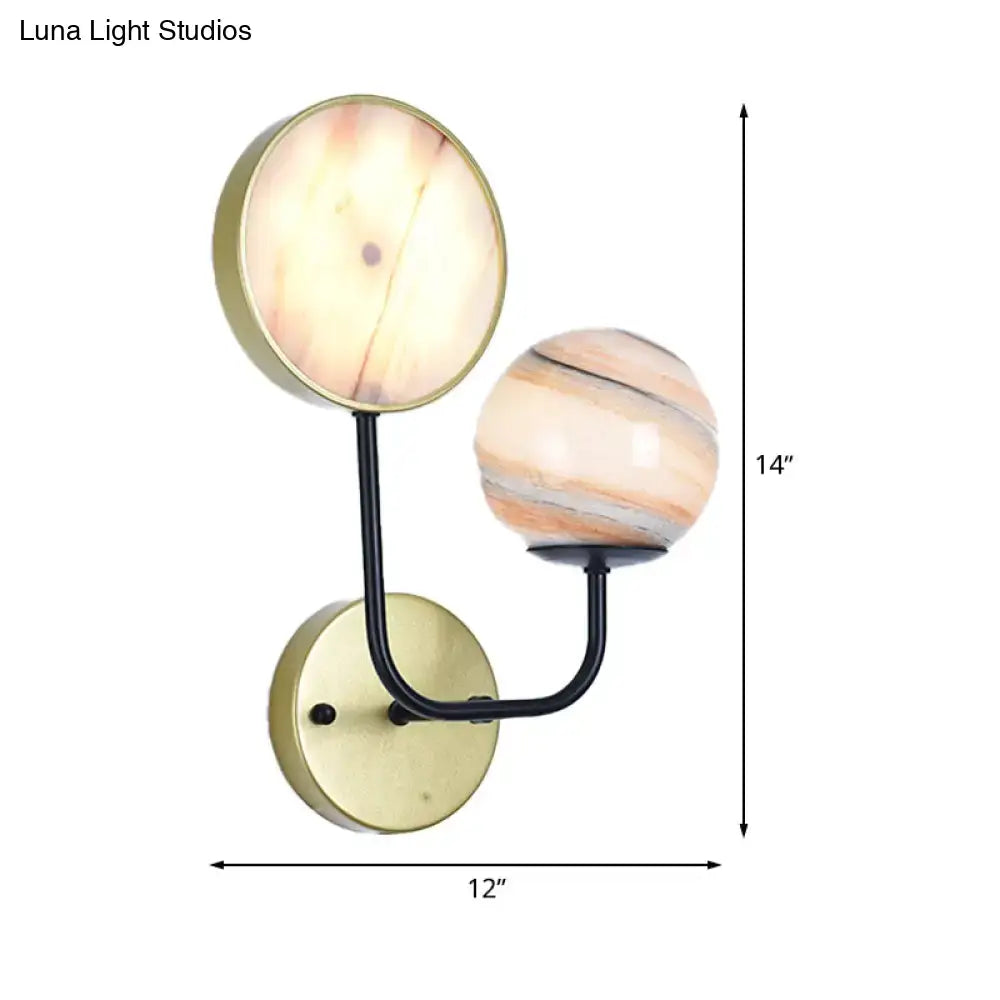 Modern peach and cream glass sconce light with brass base and black arms features two shades in warm marbled patterns