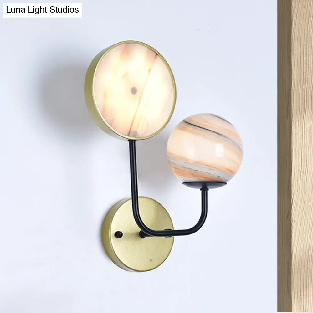 Modern peach and cream glass sconce light with brass base and black arms featuring amber marble and striped globe shades inches fixture