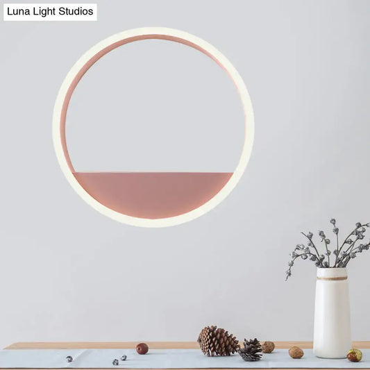 Modern pink and blue iron hoop wall light with circular white frame and soft rose gold illuminated lower half for bedroom use