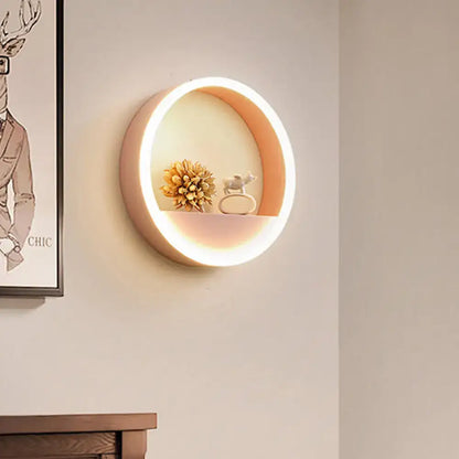 Modern pink and blue iron hoop wall light with warm peach glowing interior and illuminated edge for bedroom storage rack