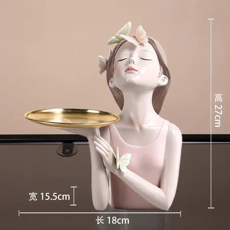A delicate pink butterfly girl resin figure holding a gold tray with white and peach butterflies for living room decor