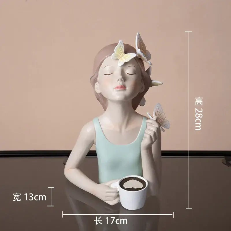 A serene light blue butterfly girl resin figure with butterflies in hair holding a white mug on a gold tray decor