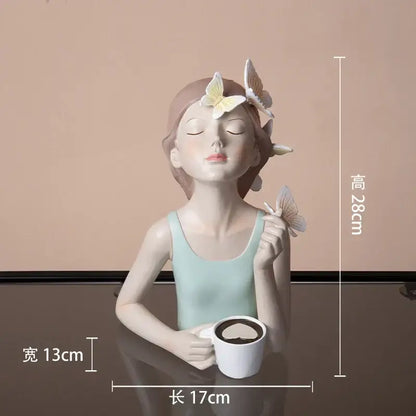 A serene light blue butterfly girl resin figure with butterflies in hair holding a white mug on a gold tray decor