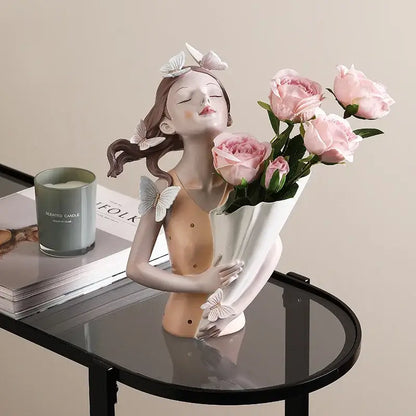 A porcelain resin butterfly girl sculpture in pink holding roses with delicate white butterfly accents for living room decor