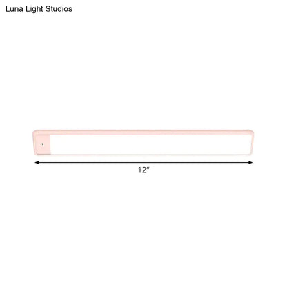 A sleek 12-inch plastic elongated vanity lighting fixture with soft pink casing and bright white panel for bedroom use