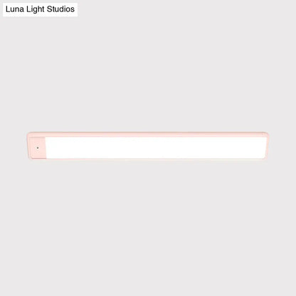 Modern pink elongated vanity lighting fixture with sleek white illuminated surface and plastic elongated vanity frame