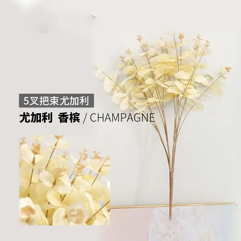 Modern pink eucalyptus flower arrangement in a glass vase with delicate champagne-colored artificial eucalyptus leaves