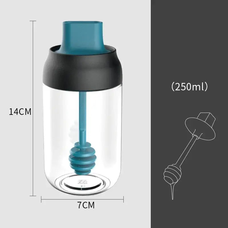 A clear glass seasoning bottle with teal and black lid and integrated teal honey dipper in modern pink glass set