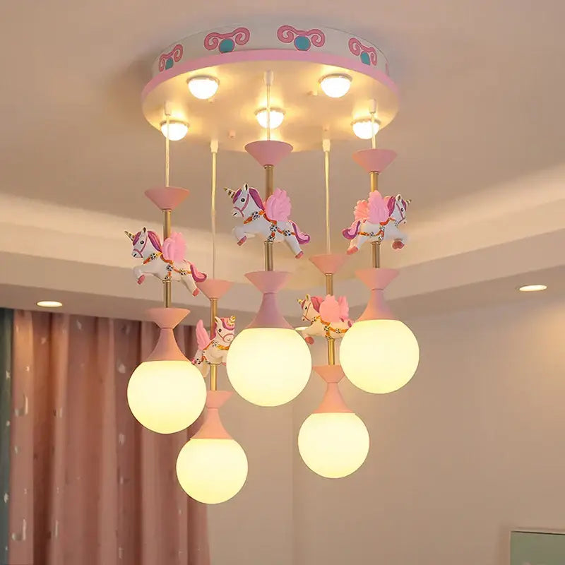 Modern pink and gold unicorn led chandelier with spherical frosted glass shades and decorative golden poles for girls bedroom decorbites kids led