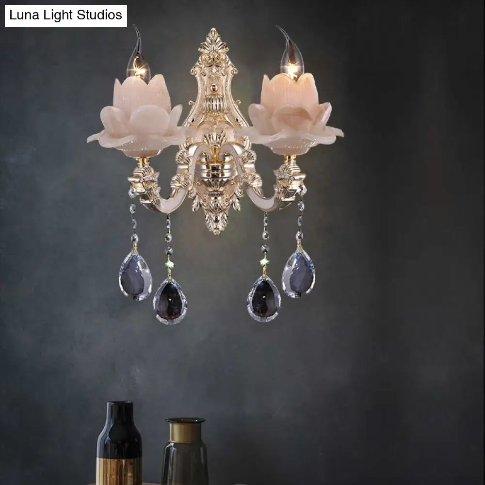 Elegant gold-toned wall lamp with milky glass pink floral shades and teardrop crystal pendants for bedroom sconce