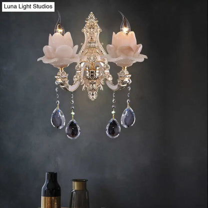 Elegant gold-toned wall lamp with milky glass pink floral shades and teardrop crystal pendants for bedroom sconce