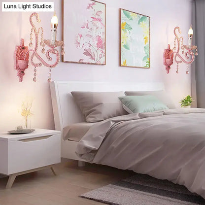 Modern pink metallic scroll arm wall lamp with crystal accents featuring ornate wall sconces for bedroom use