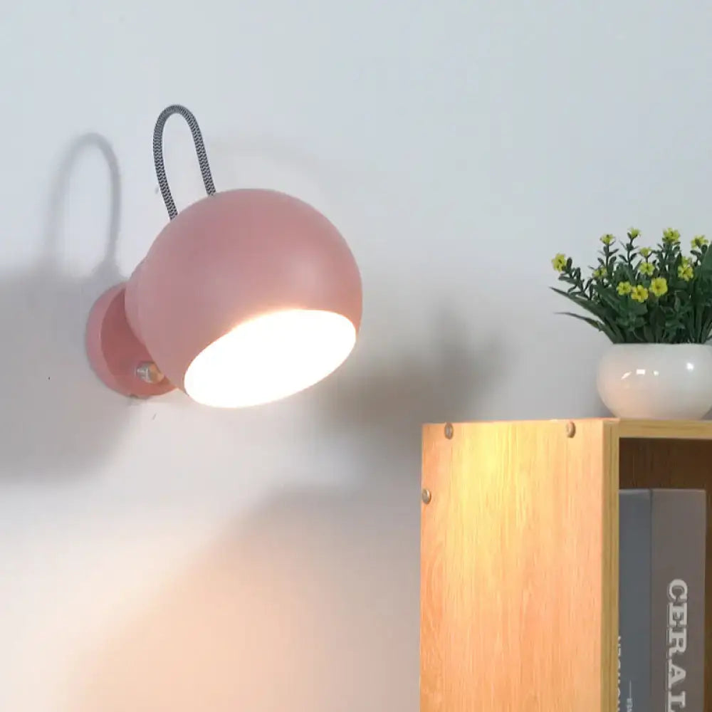 Modern pink spherical wall lamp with flexible black cord mounted on wall ideal for living room wall light decor