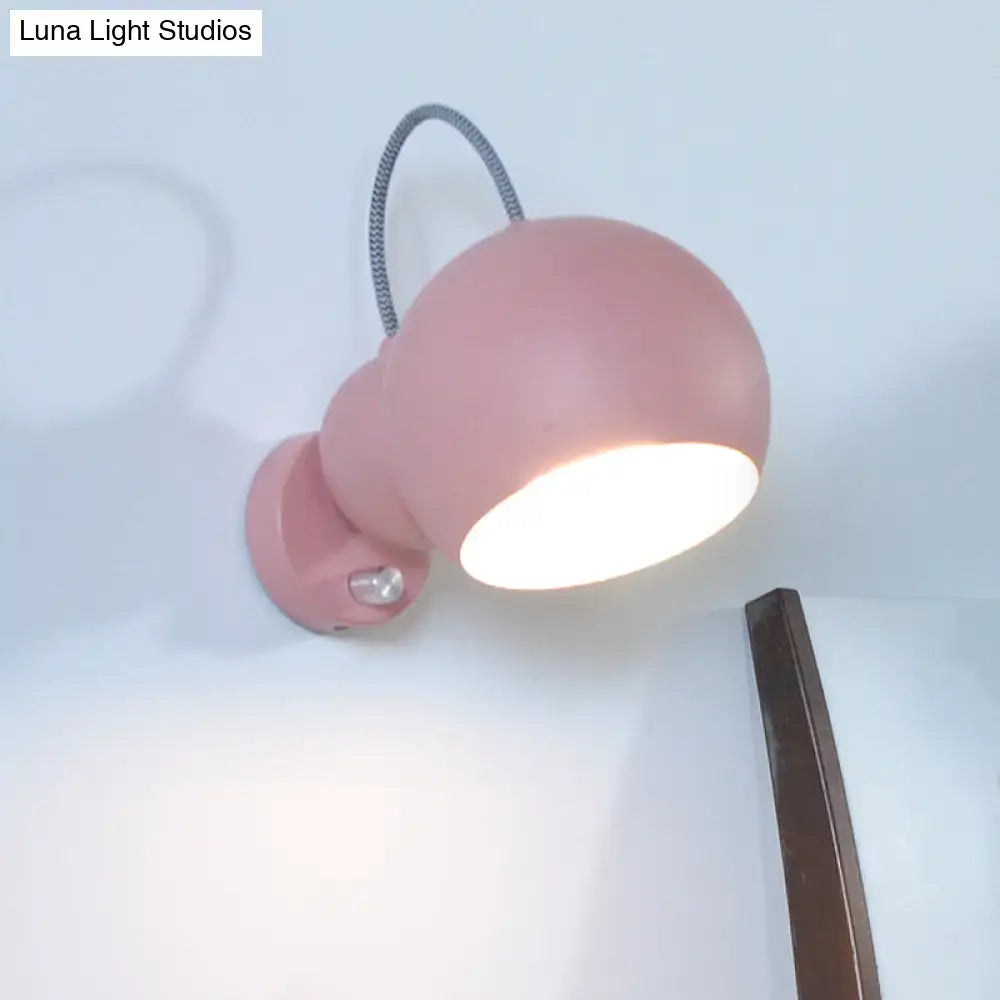 Modern pink spherical wall lamp with flexible gray cord and adjustable head ideal for living room wall light