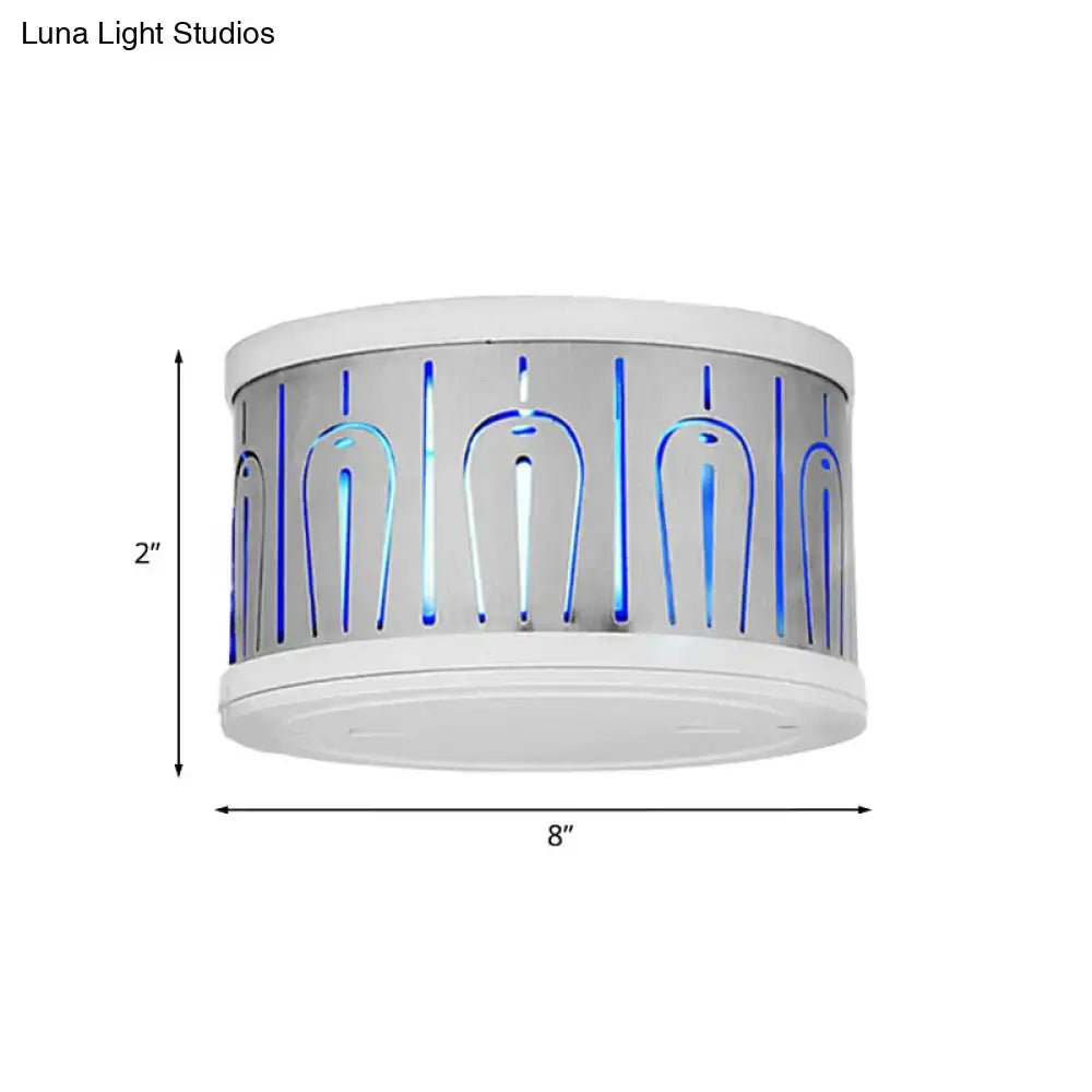 White cylindrical electric insect killer with blue glowing bars beside modern style purple and blue peacock led wall lamp