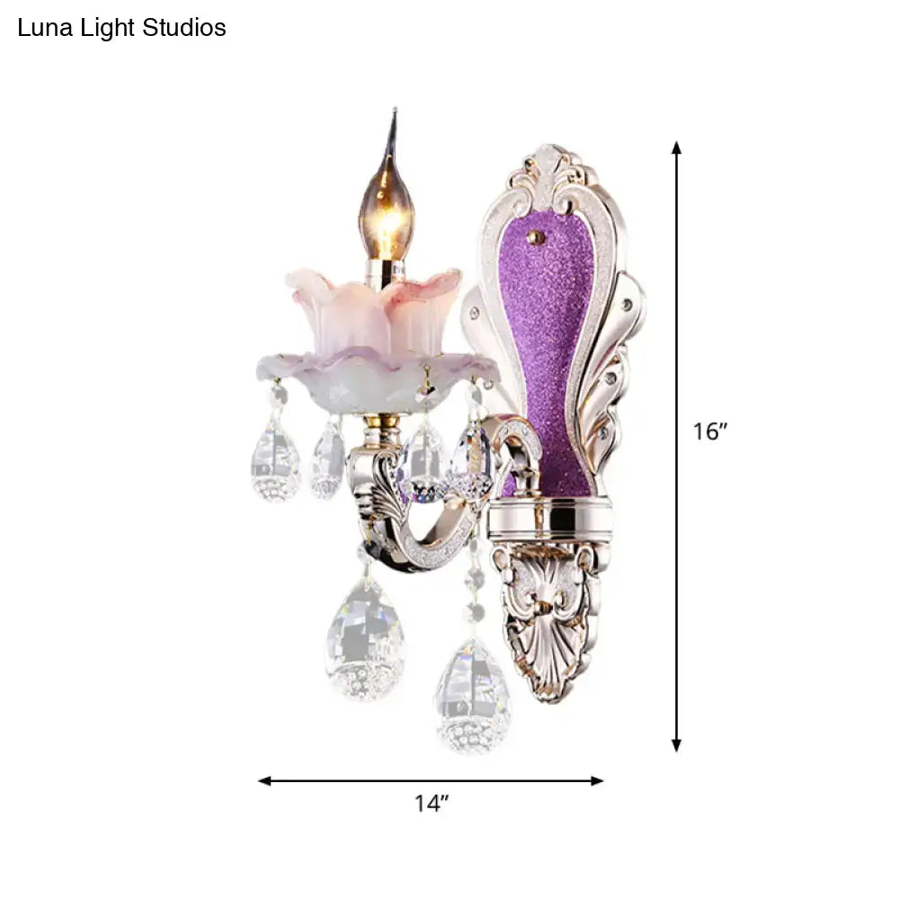 Modern purple and silver crystal wall sconce with ornate design, crystal droplets, and pink glass flower accent for bedroom lighting