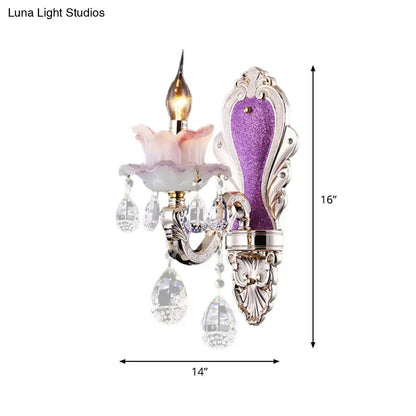 Modern purple and silver crystal wall sconce with ornate design, crystal droplets, and pink glass flower accent for bedroom lighting