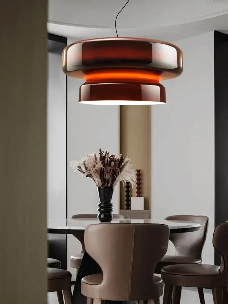 A modern tiered pendant light with warm amber decorbites italian glass and metallic accents for dining room decor