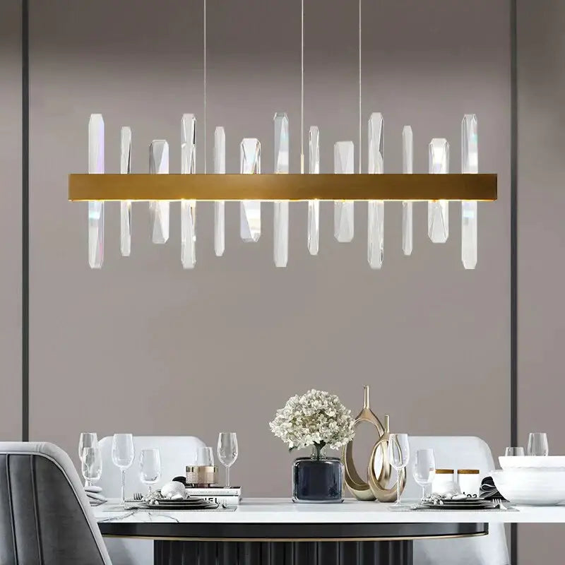 Modern rectangle gold crystal chandelier featuring clear vertical rods suspended from a central gold bar by DecorBites