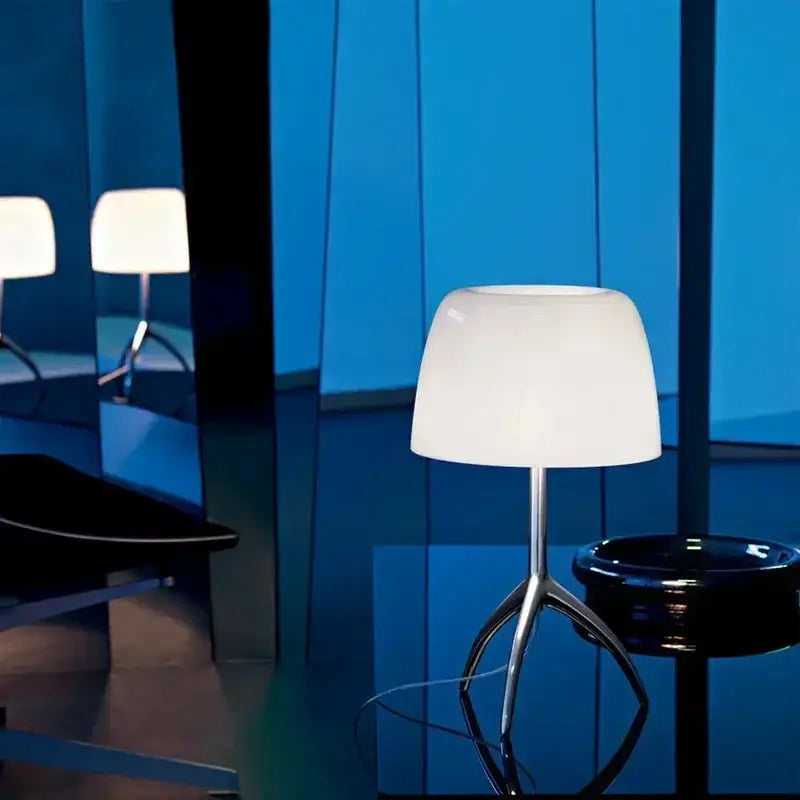 Modern table lamp with white opaline glass shade and sleek chrome tripod base for bedroom use