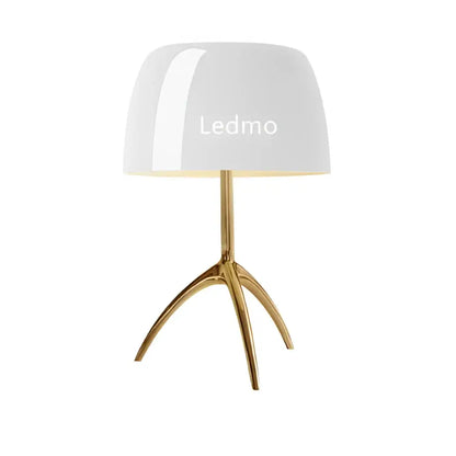 Modern table lamp with white glossy glass shade and gold-toned tripod base for bedroom use