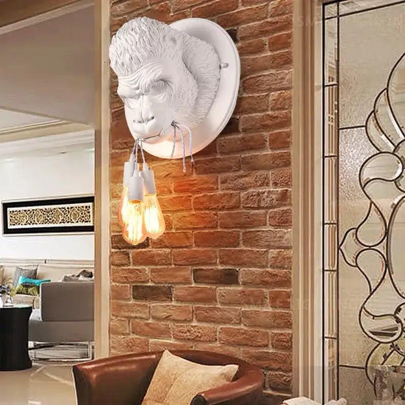 Modern retro dark gray gorilla resin wall lamp with white sculpted monkey head and three filament bulbs decorbites gorilla resin wall