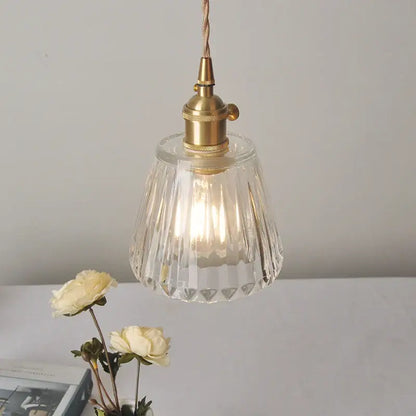 Modern ribbed clear glass led pendant light featuring faceted clear glass and a brass finish metal fixture by decorbites