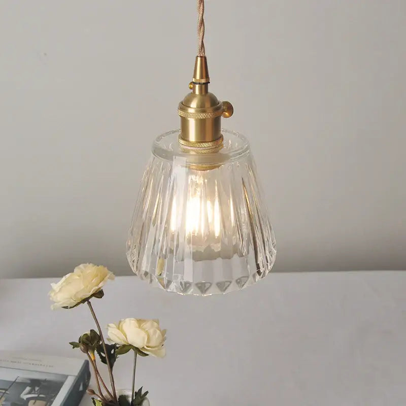 Modern ribbed clear glass led pendant light featuring faceted clear glass and a brass finish metal fixture by decorbites