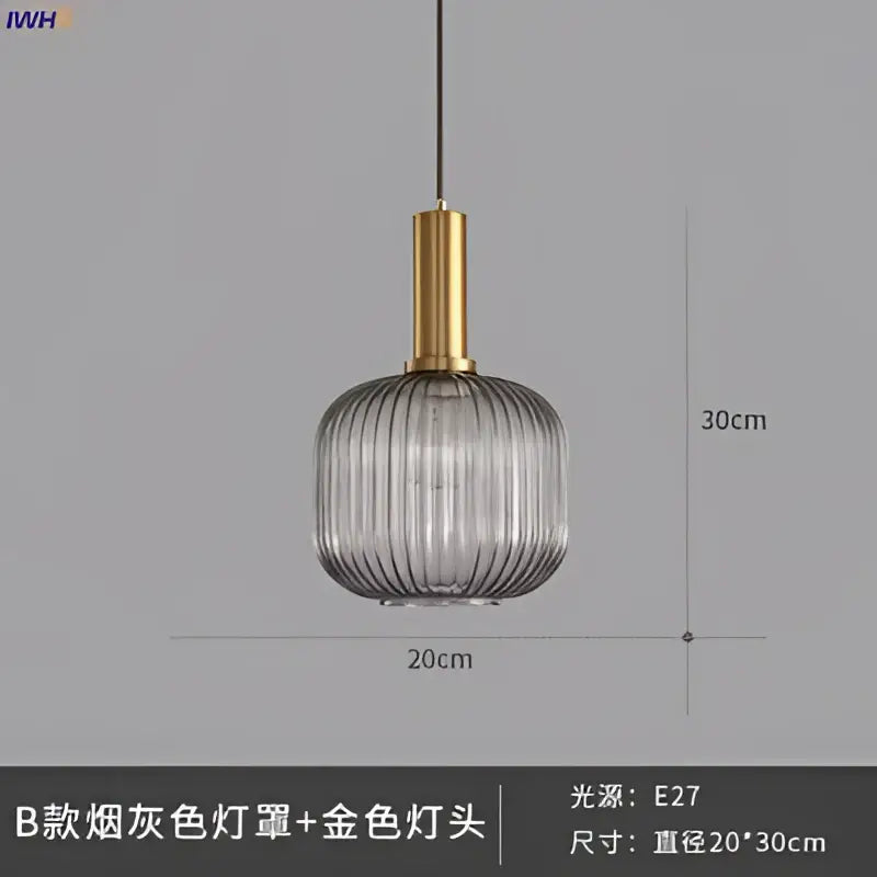 A modern glass pendant light with a smoked gray ribbed glass shade and brass stem for dining room use
