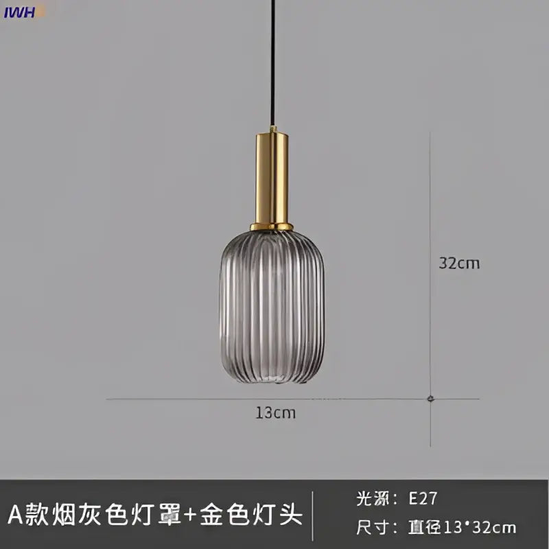 A modern ribbed smoked gray glass pendant light with gold-toned brass stem for dining room use